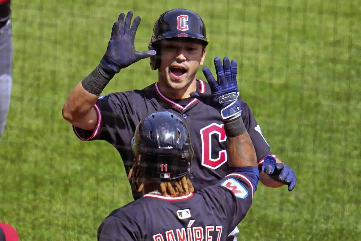 Cleveland Guardians' Steven Kwan, top, is greeted by José Ramírez as he returns to the dugout after hitting a two-run home run off Pittsburgh Pirates pitcher Mitch Keller during the third inning of a baseball game in Pittsburgh, Sunday, April 20, 2025. (AP Photo/Gene J. Puskar)