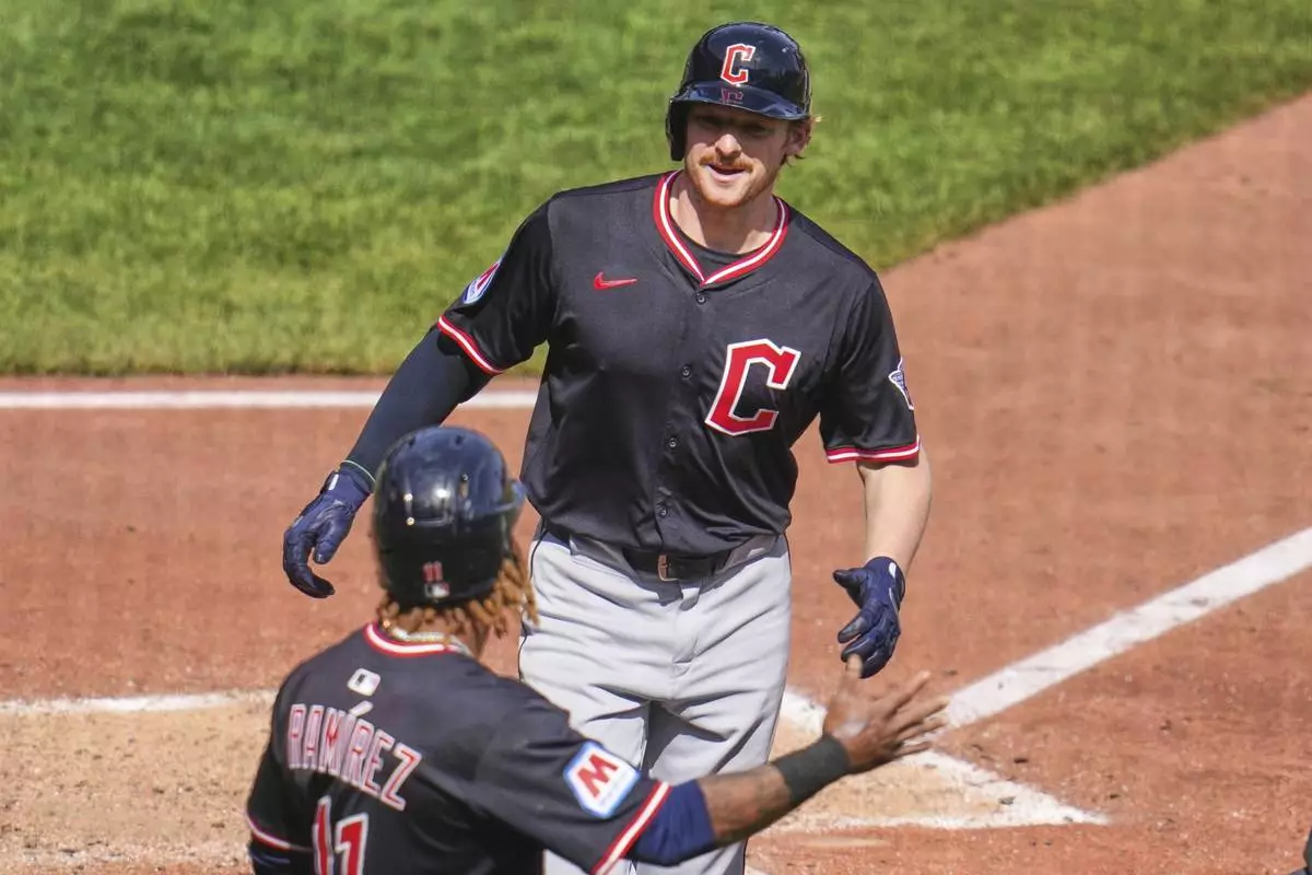 Cleveland Guardians' Kyle Manzardo, top, is greeted by José Ramírez (11) as he crosses home plate after hitting a two-run home run off Pittsburgh Pirates pitcher Joey Wentz (34) during the seventh inning of a baseball game in Pittsburgh, Sunday, April 20, 2025. (AP Photo/Gene J. Puskar)