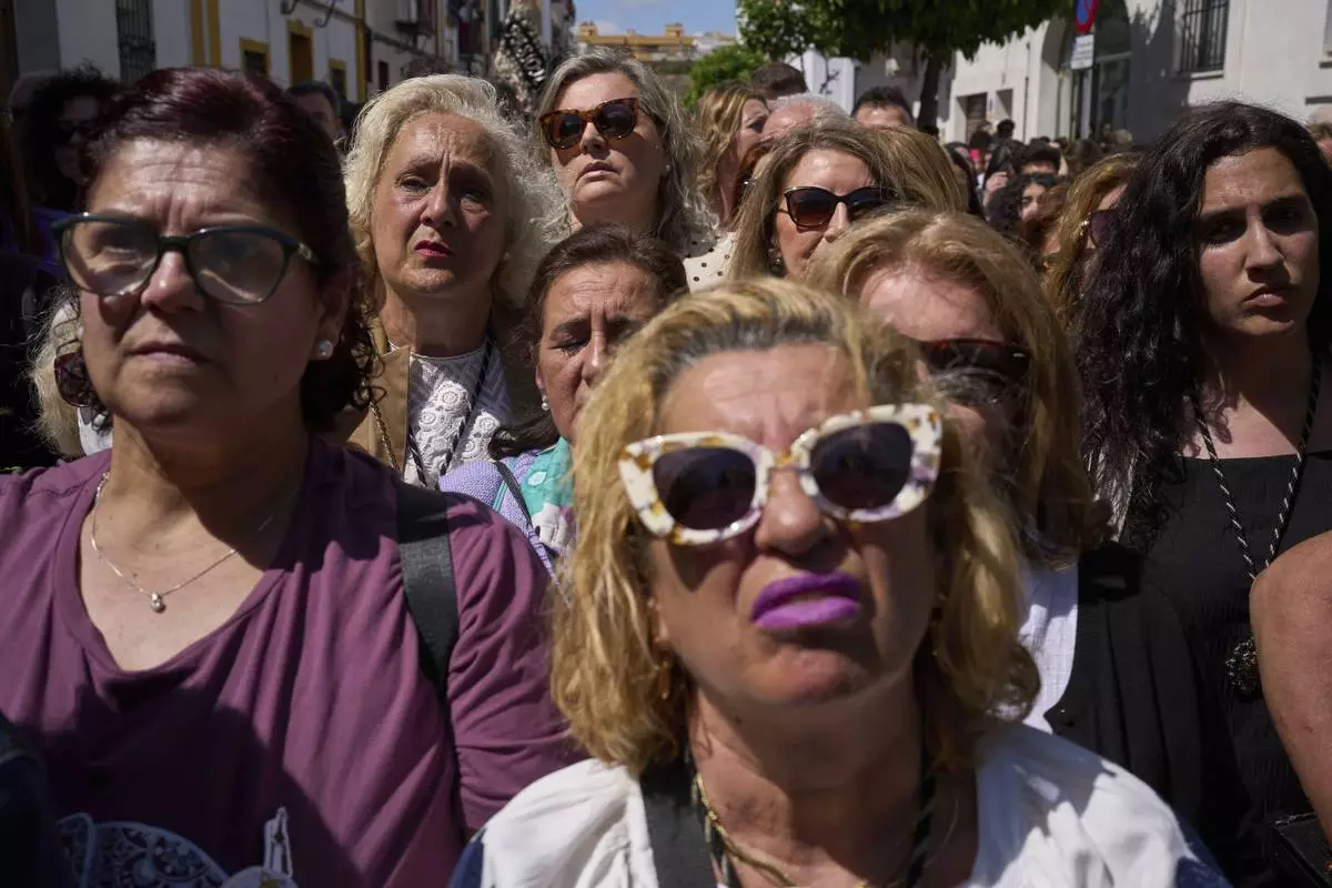 Faithful watch a 'Santa Genoveva' brotherhood Holy Week procession in Seville, Spain, Monday, April 14, 2025. (AP Photo/Emilio Morenatti)