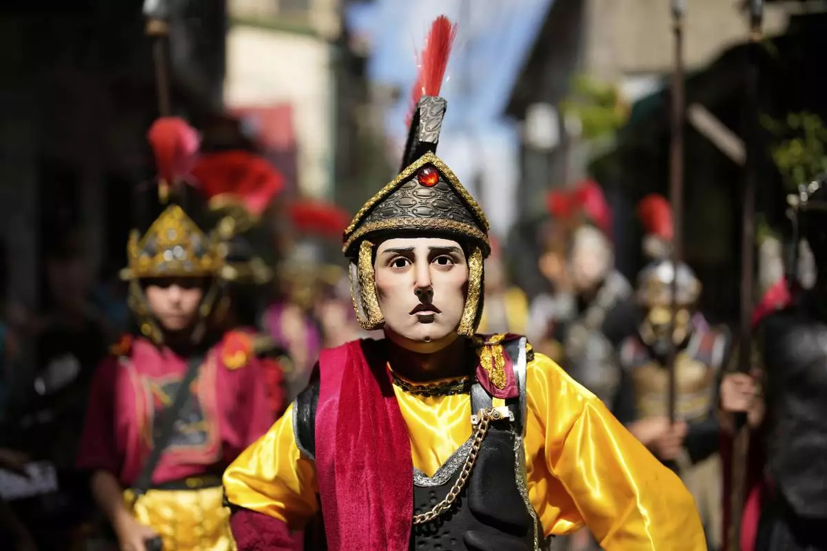Performers dressed as Roman soldiers walk around town as they reenact the passion and sufferings of Jesus Christ as part of their lenten practice to mark Maundy Thursday, April 17, 2025 in Paete town, Laguna province, Philippines. (AP Photo/Aaron Favila)