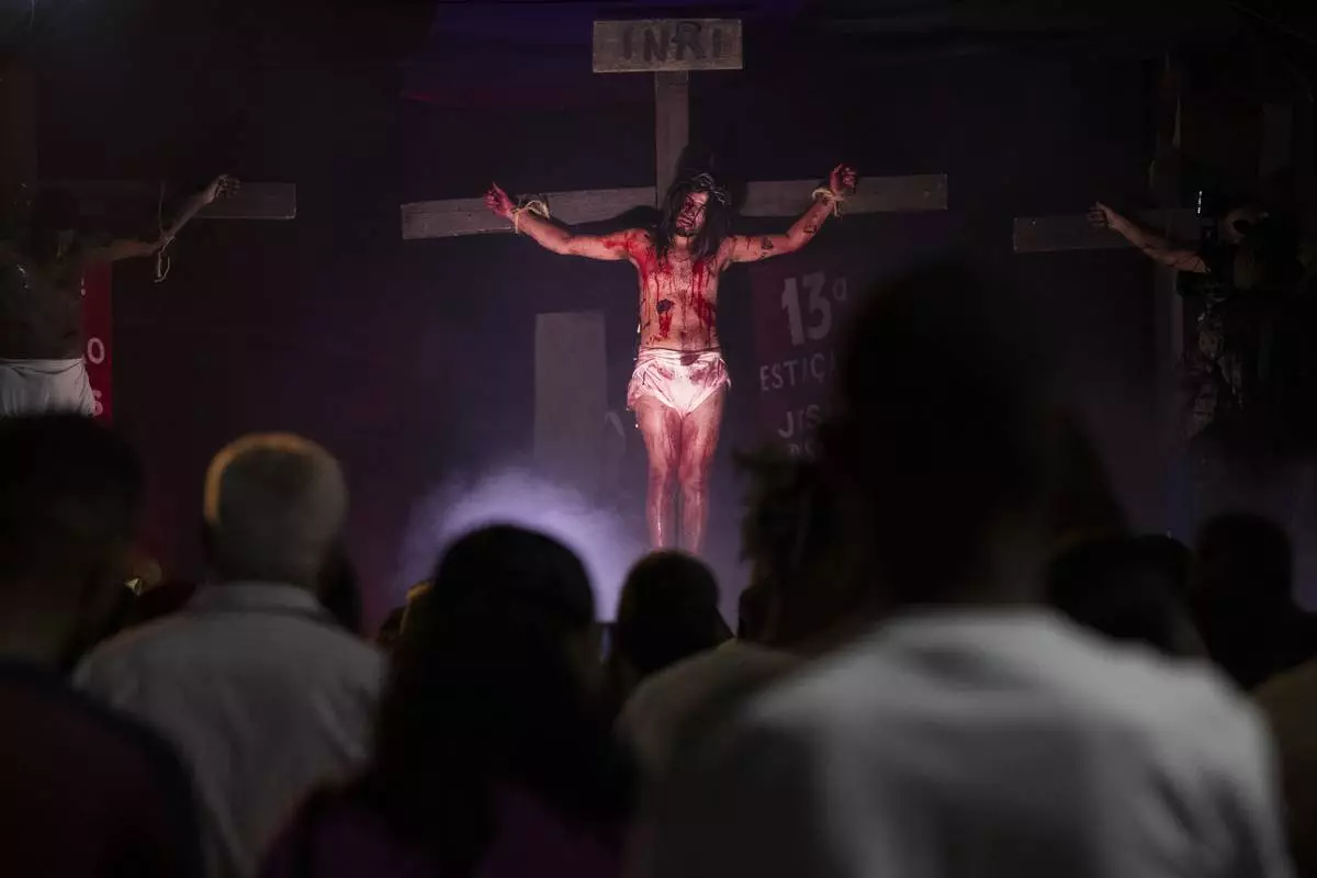 Luiz Henrique, playing the role of Jesus Christ, hangs on a cross during a Way of the Cross reenactment as part of Holy Week celebrations, at the Complexo do Alemao favela in Rio de Janeiro, Brazil, on Good Friday, April 18, 2025. (AP Photo/Bruna Prado)