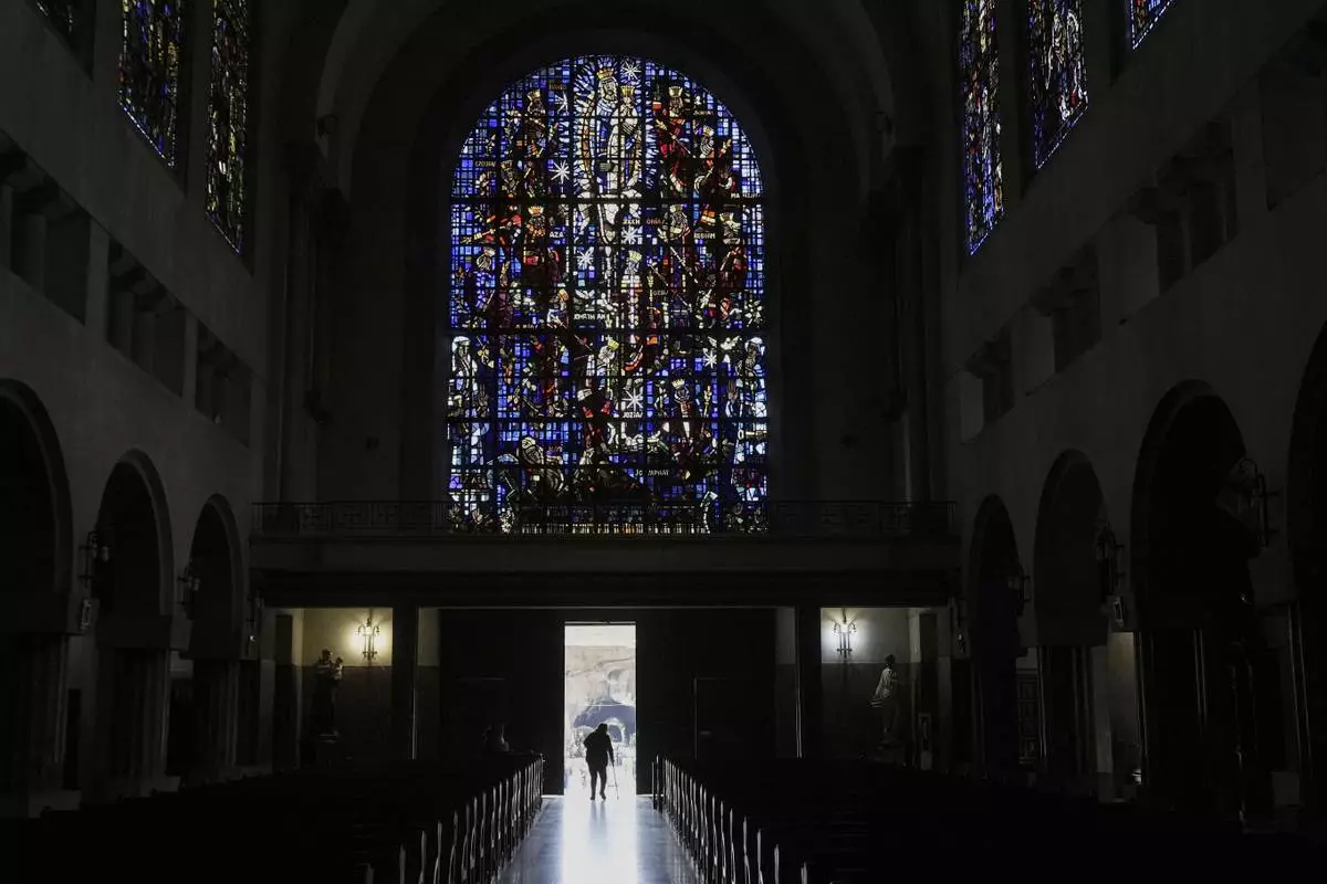 A parishioner leaves the Santuario de la Virgen de Lourdes after prayers during Holy Week in Santiago, Chile, Thursday, April 17, 2025. (AP Photo/Esteban Felix)