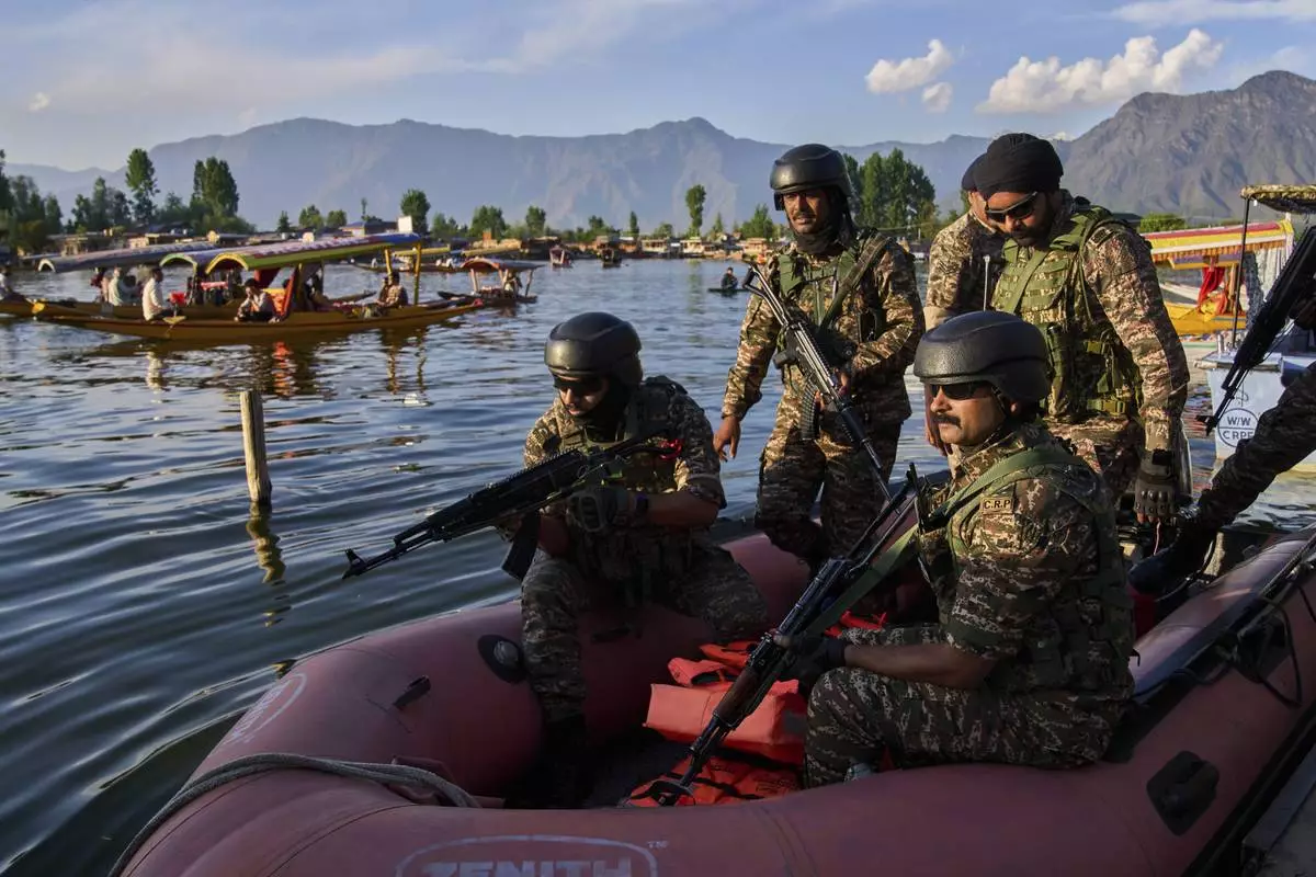 Paramilitary soldiers board a patrol boat as Indian tourists take boat rides on Dal Lake in Srinagar, Indian controlled Kashmir, Friday, April 25, 2025. (AP Photo/Dar Yasin)