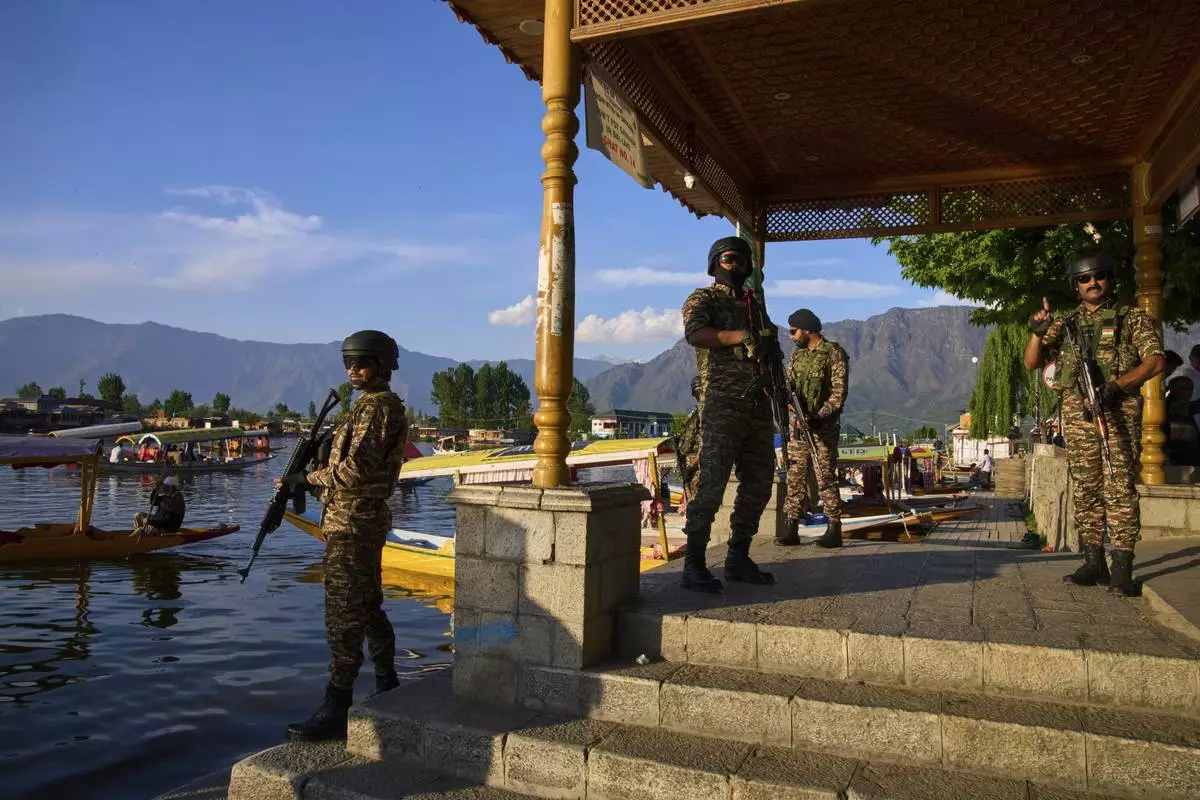 Paramilitary soldiers stand guard at the banks of Dal Lake as Indian tourists take boat rides in Srinagar, Indian controlled Kashmir, Friday, April 25, 2025. (AP Photo/Dar Yasin)