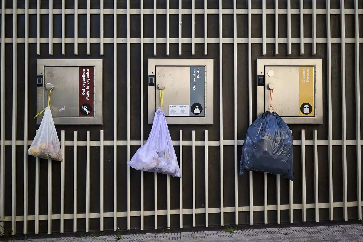 Garbage bags hang from the doors of electric recycling bins during a massive power outage in Pamplona, northern Spain, Monday, April 28, 2025. (AP Photo/Miguel Oses)