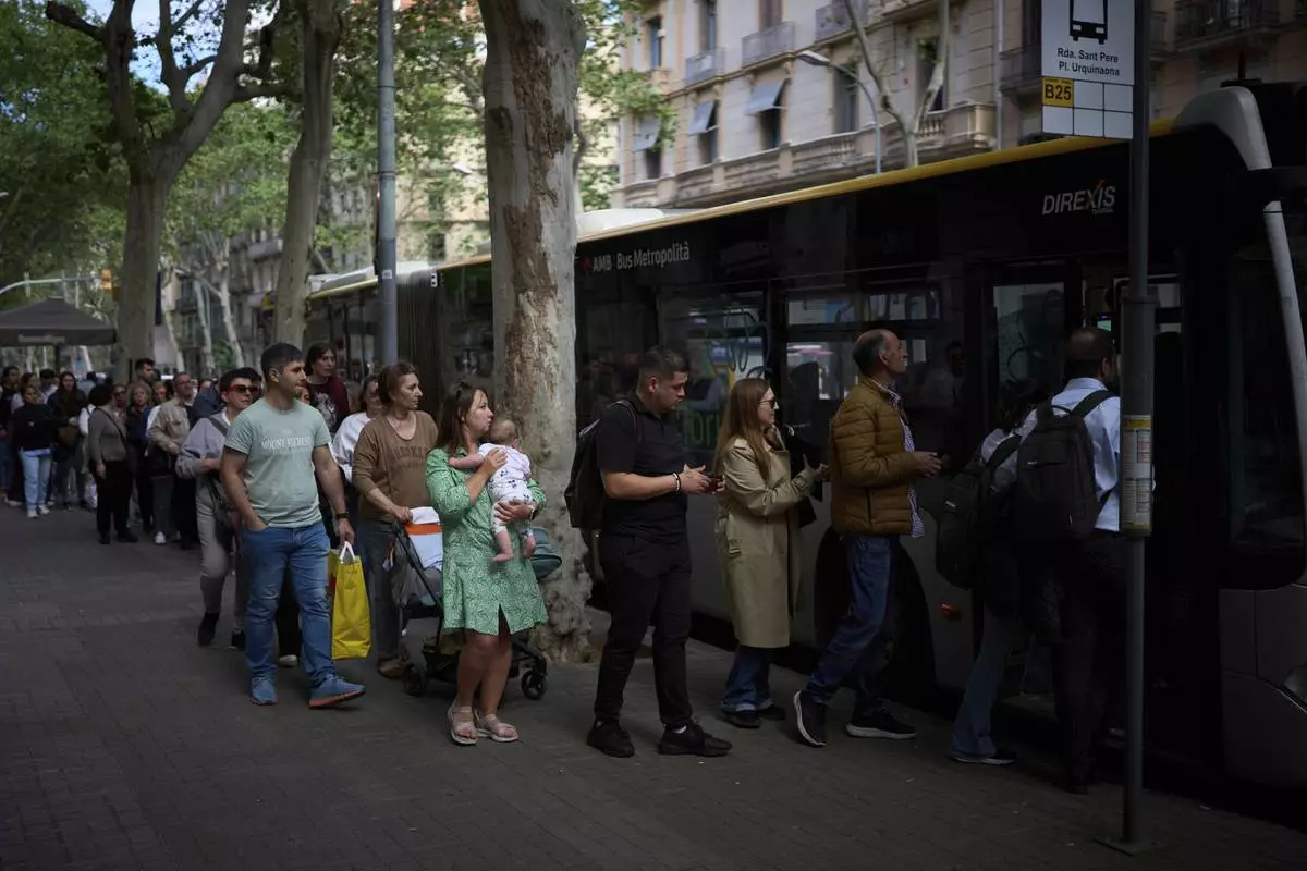 People board a bus, during a major power outage in Barcelona, Spain, Monday, April 28, 2025. (AP Photo/Emilio Morenatti)