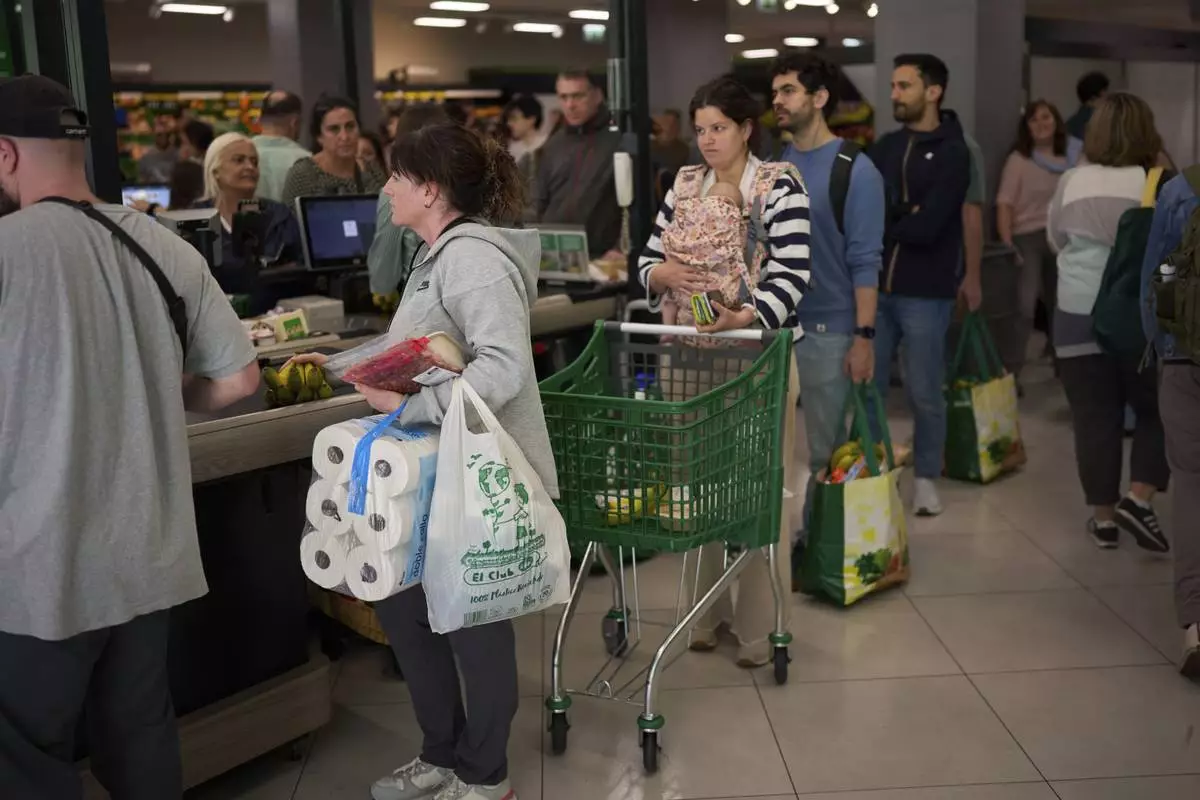 People buy food at a supermarket, during a major power outage in Barcelona, Spain, Monday, April 28, 2025. (AP Photo/Emilio Morenatti)