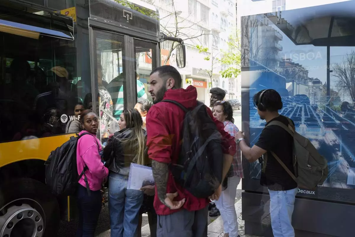 People fail to board a crowded bus after the subway stopped running following a power outage in Lisbon, Portugal, Monday, April 28, 2025. (AP Photo/Armando Franca)
