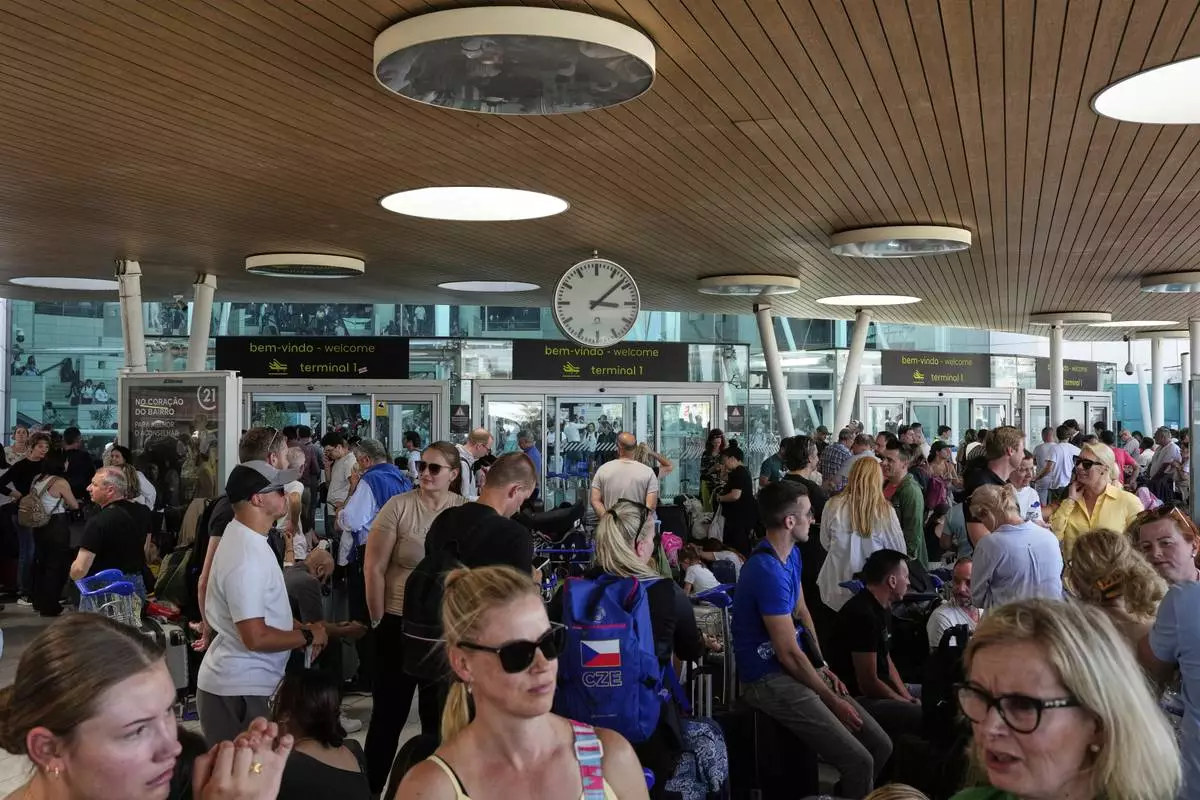 Passengers wait outside Lisbon Airport during a nationwide power outage in Lisbon, Monday, April 28, 2025. (AP Photo/Armando Franca)