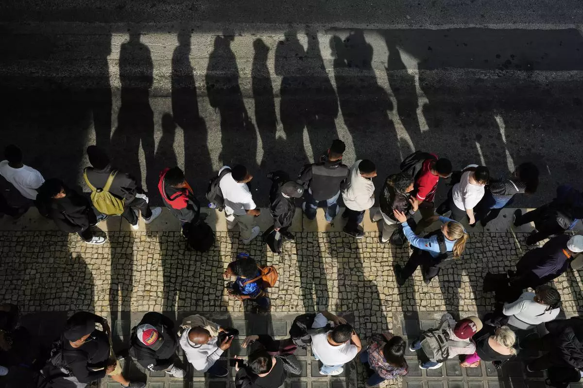 Passengers queue at Oriente transportation hub during a nationwide power outage in Lisbon, Monday, April 28, 2025. (AP Photo/Armando Franca)