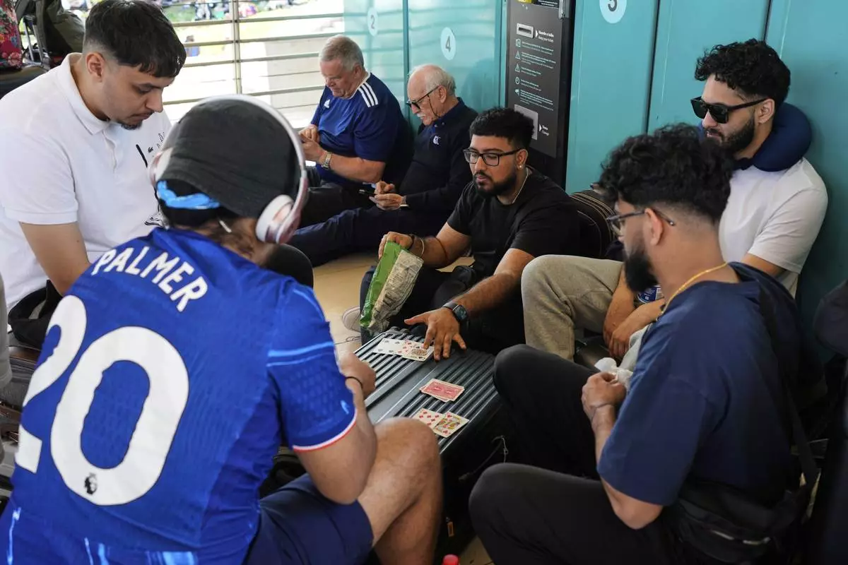 Passengers play cards at Lisbon Airport during a nationwide power outage in Lisbon, Monday, April 28, 2025. (AP Photo/Armando Franca)