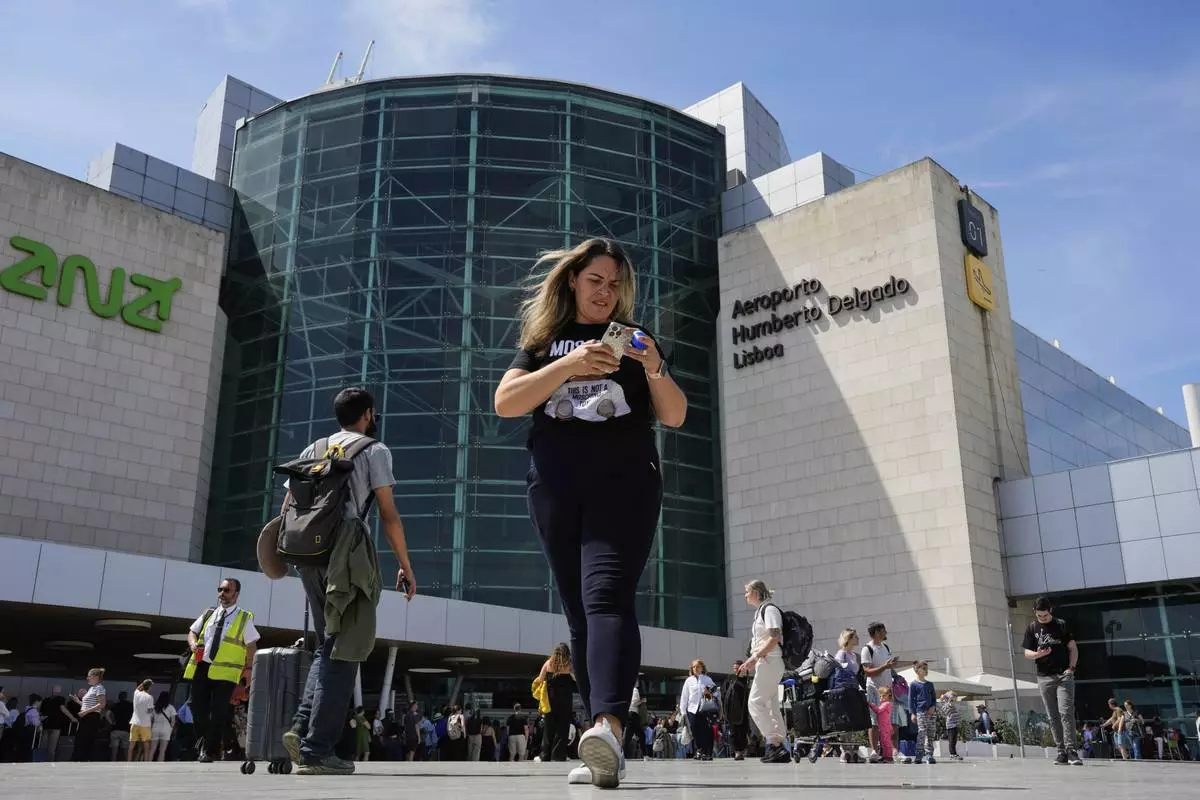 Passengers outside Lisbon Airport during a nationwide power outage in Lisbon, Monday, April 28, 2025. (AP Photo/Armando Franca)