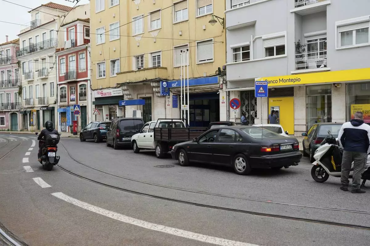 People queue for petrol and at an ATM in Lisbon, Tuesday, April 29, 2025, the day after a nationwide power outage that shut down gas stations and ATMs. (AP Photo/Armando Franca)
