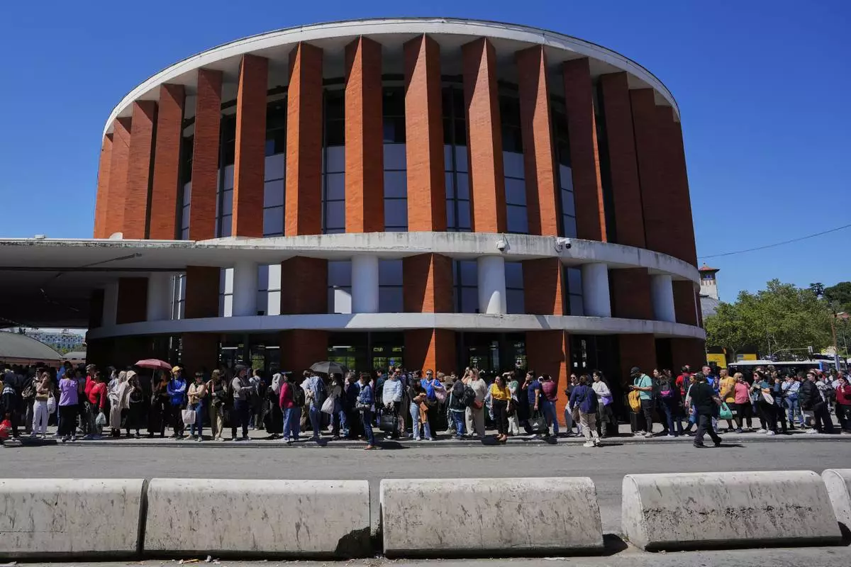 Passengers wait outside Atocha train station during a nationwide power outage in Madrid, Monday, April 28, 2025. (AP Photo/Manu Fernandez)