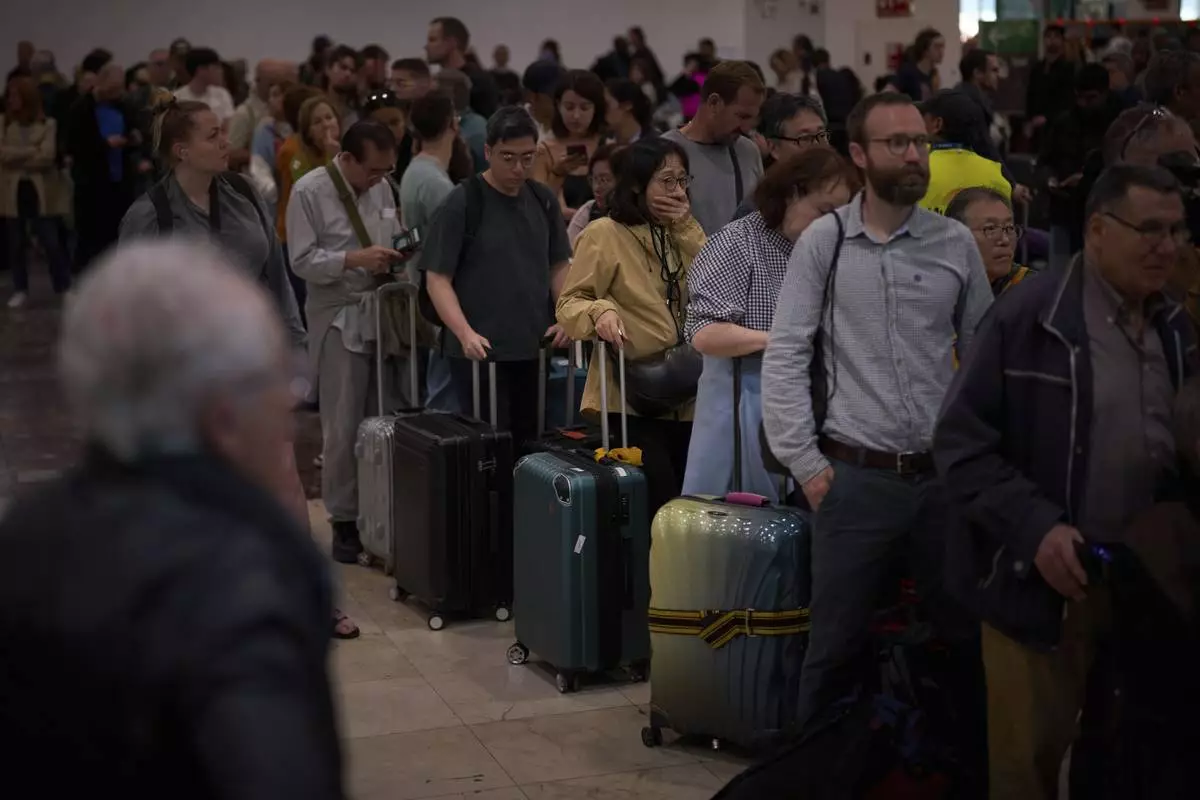 Passengers crowd the train accesses at Sants train station in Barcelona, Spain, Tuesday, April 29, 2025. (AP Photo/Emilio Morenatti)