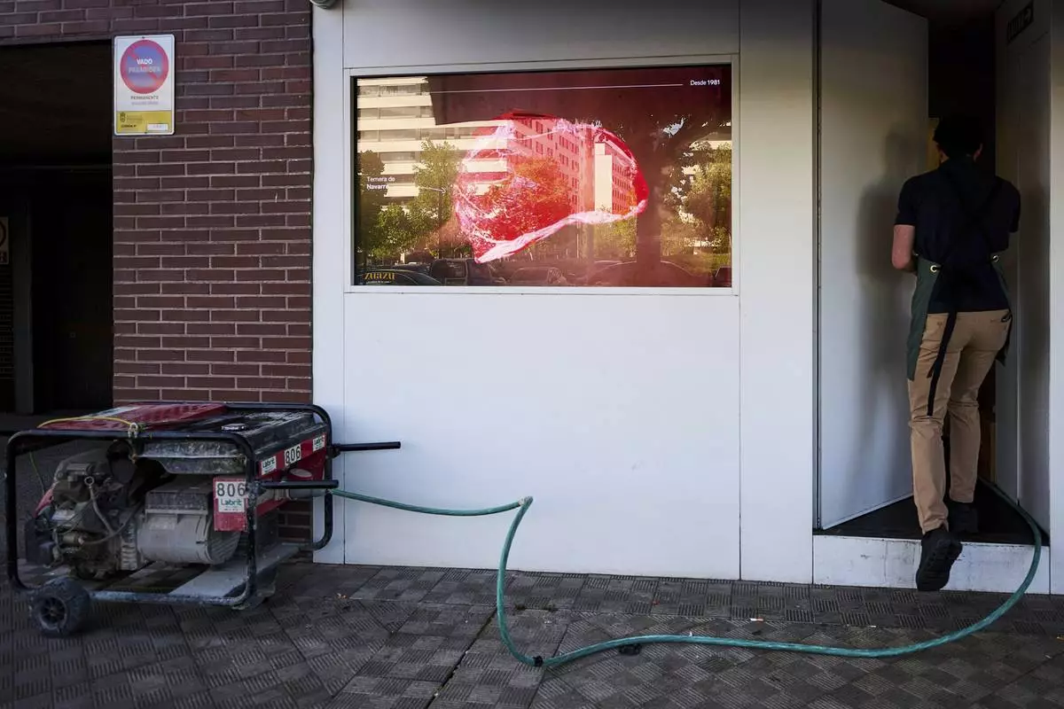 A generator powers a meat shop during a massive power outage in Pamplona, northern Spain, Monday, April 28, 2025. (AP Photo/Miguel Oses)