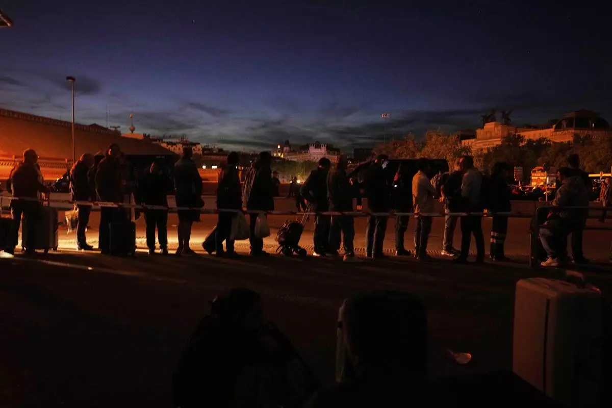 People gather outside Atocha train station during a major power outage in Madrid, Monday, April 28, 2025. (AP Photo/Manu Fernandez)