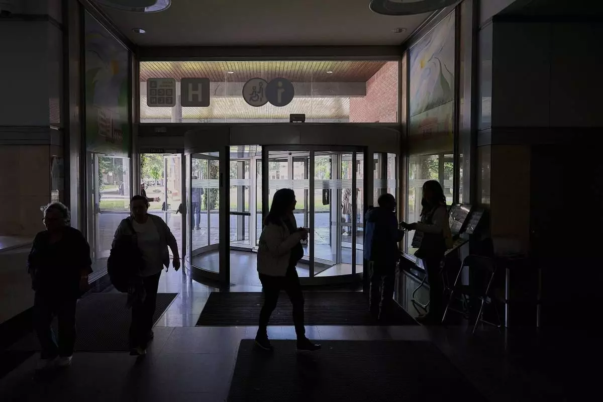 People walk inside a hospital during a nationwide power outage in Pamplona, northern Spain, Monday, April 28, 2025. (AP Photo/Miguel Oses)