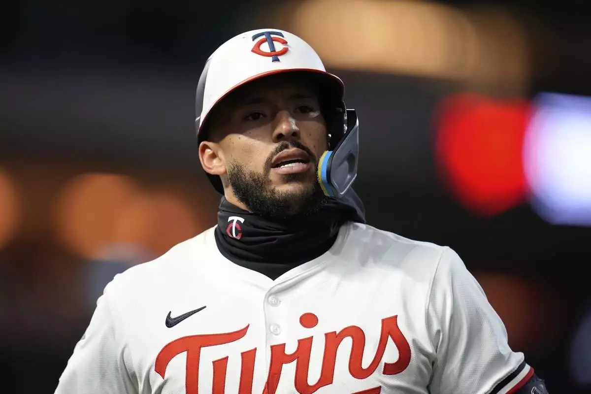 Minnesota Twins' Carlos Correa walks back to the dugout after hitting a flyout to left during the ninth inning of a baseball game against the New York Mets, Monday, April 14, 2025, in Minneapolis. (AP Photo/Abbie Parr)