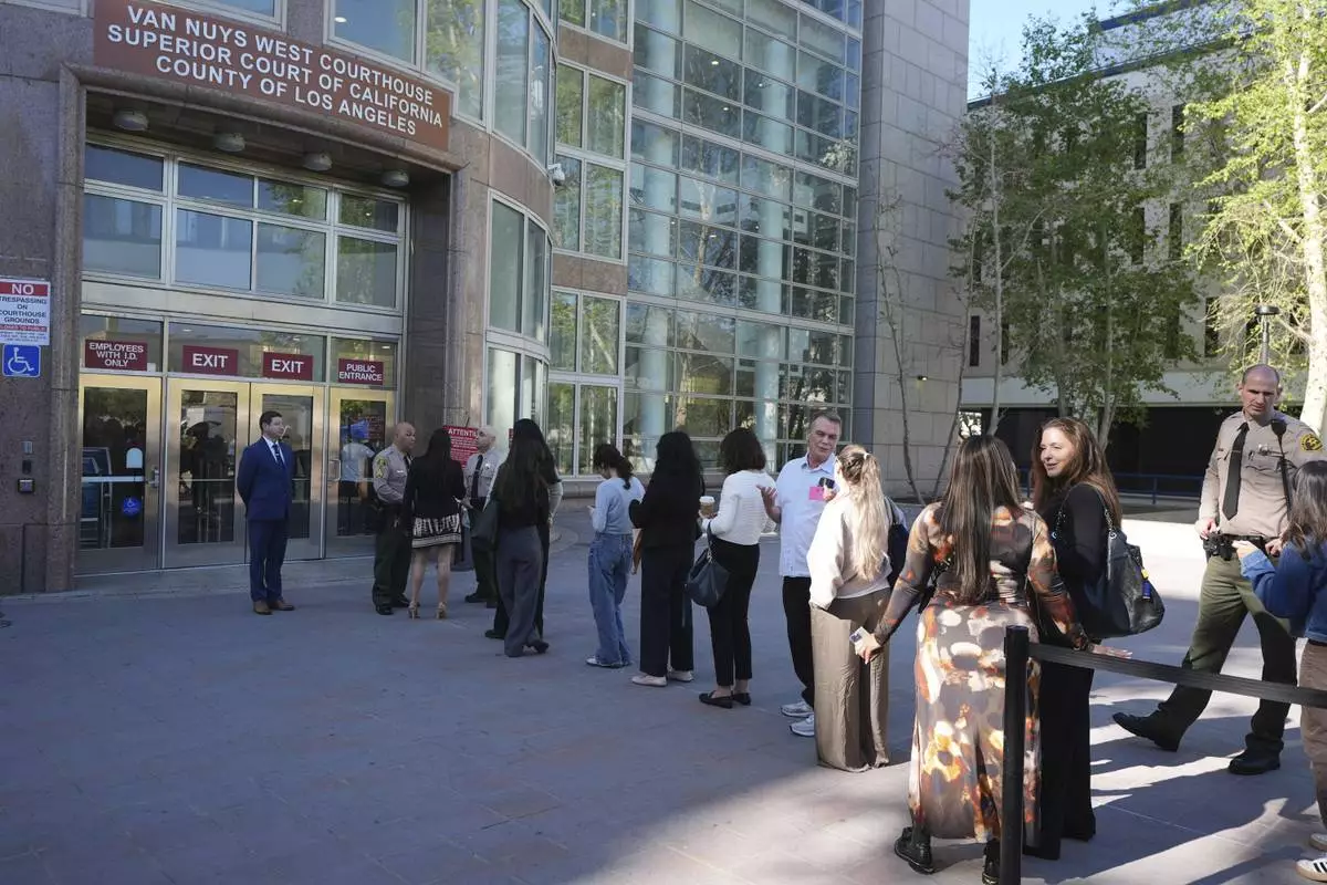 People form a line outside the Van Nuys West Courthouse before a hearing regarding the case of Erik and Lyle Menendez Friday, April 11, 2025, in Los Angeles. (AP Photo/Damian Dovarganes)
