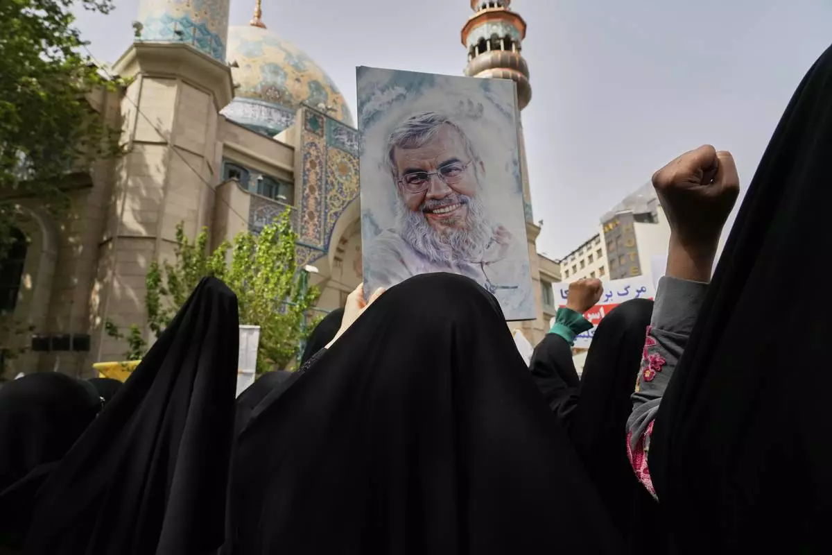 Iranian protesters chant slogans as one of them holds up a poster of Lebanon's Hezbollah former leader Hassan Nasrallah, who was killed by Israel, during an anti-Israeli demonstration at the Felestin (Palestine) Sq. in Tehran, Iran, Wednesday, April 9, 2025. (AP Photo/Vahid Salemi)