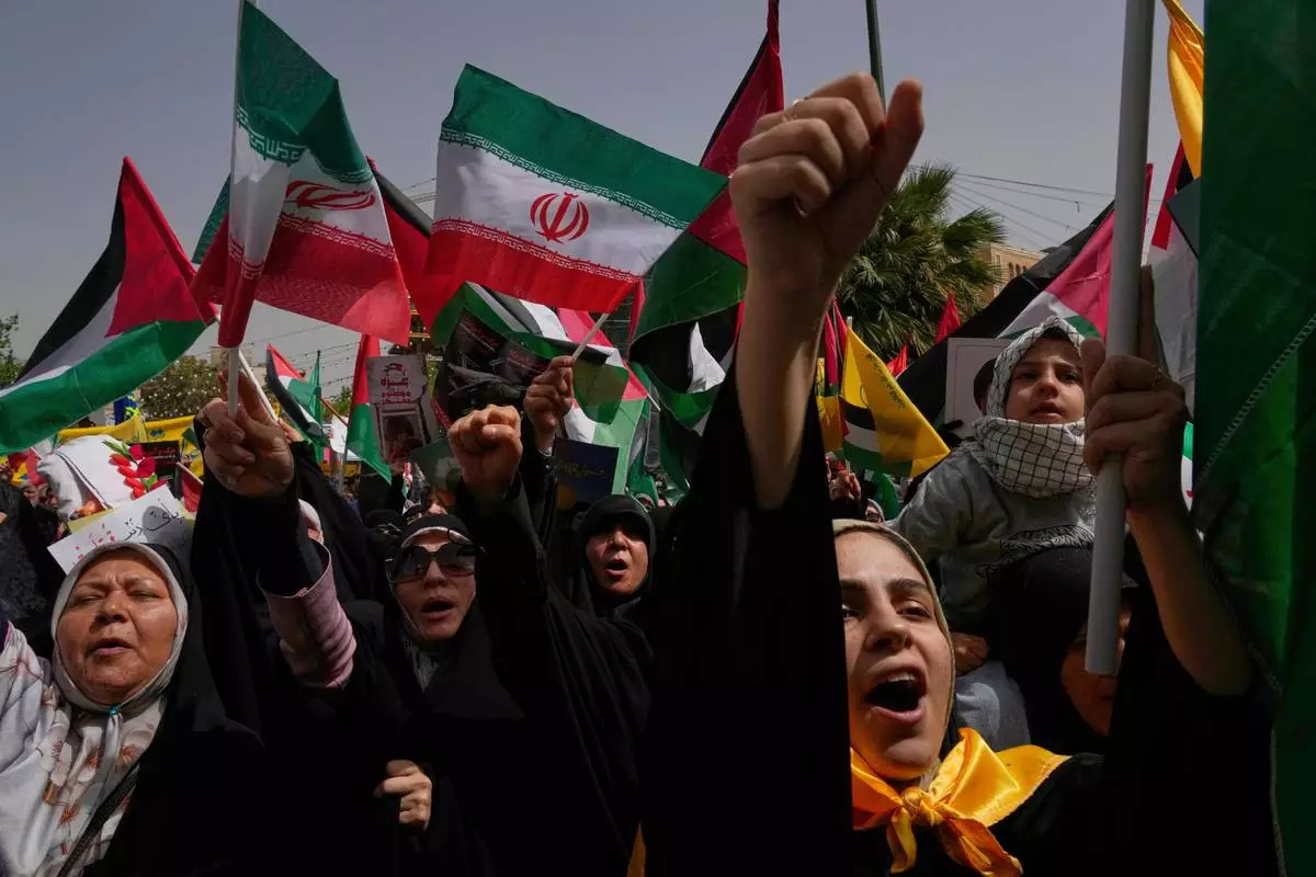 Iranian protesters chant slogans as they wave Palestinian and their country's flags during an anti-Israeli demonstration at the Felestin (Palestine) Sq. in Tehran, Iran, Wednesday, April 9, 2025. (AP Photo/Vahid Salemi)