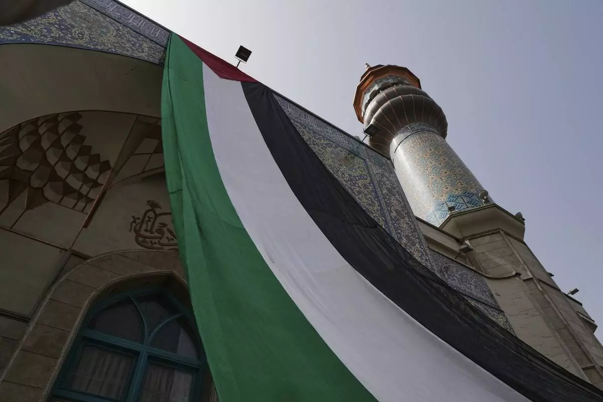 A huge Palestinian flag hangs on a mosque during an anti-Israel protest at the Felestin (Palestine) Sq. in Tehran, Iran, Wednesday, April 9, 2025. (AP Photo/Vahid Salemi)