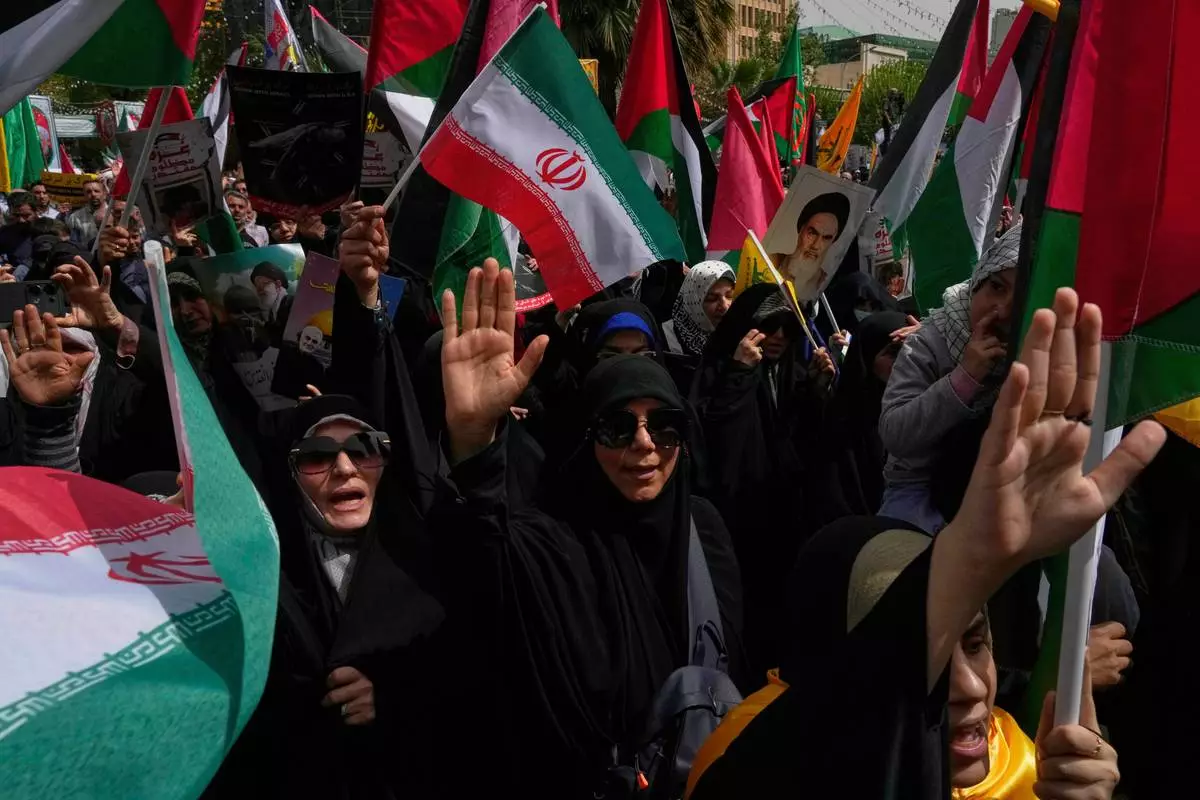 Iranian protesters chant slogans as they wave Iranian and Palestinian flags during an anti-Israel demonstration at the Felestin (Palestine) Sq. in Tehran, Iran, Wednesday, April 9, 2025. (AP Photo/Vahid Salemi)