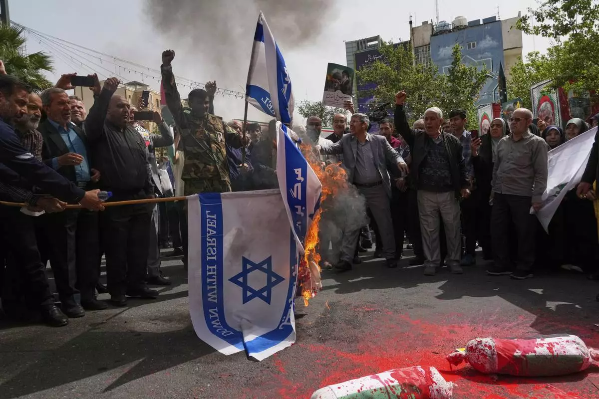 Iranian protesters burn representations of the Israeli flag during a demonstration at the Felestin (Palestine) Sq. in Tehran, Iran, Wednesday, April 9, 2025. (AP Photo/Vahid Salemi)
