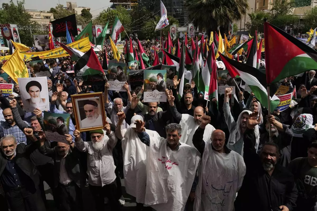Iranian protesters chant slogans as they hold Palestinian flags while some of them wear white shrouds, a symbolic gesture that shows they are prepared to die for their cause, during an anti-Israeli demonstration at the Felestin (Palestine) Sq. in Tehran, Iran, Wednesday, April 9, 2025. (AP Photo/Vahid Salemi)