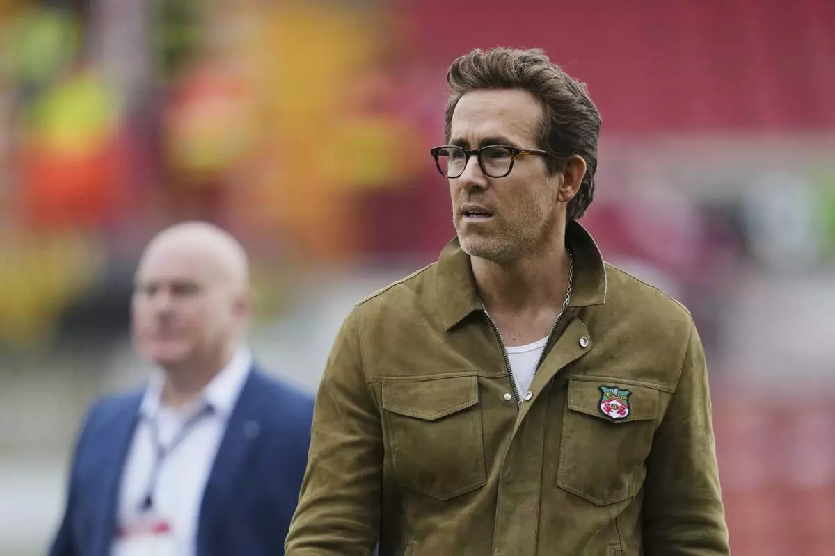 Wrexham co-owners Ryan Reynolds walks on the field before the English League One soccer match between Wrexham and Charlton Athletic at the Racecourse ground in Wrexham, Wales, Saturday, April 26, 2025. (AP Photo/Jon Super)
