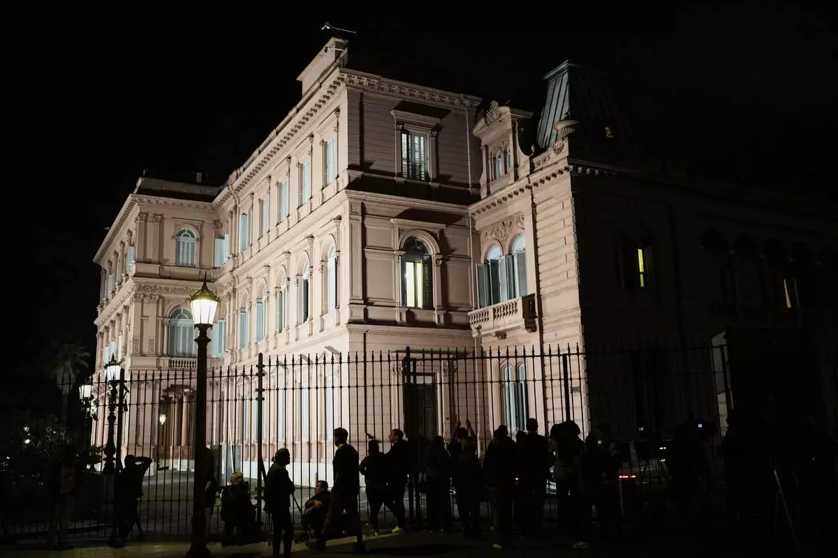 Journalists wait outside Government House where Economy Minister Luis Caputo is holding a conference, in Buenos Aires, Argentina, Friday, April 11, 2025. (AP Photo/Natacha Pisarenko)