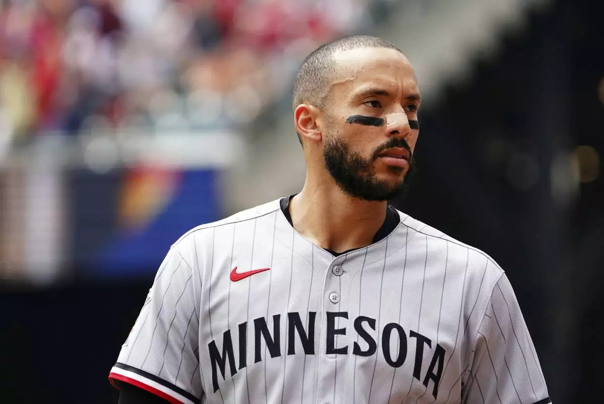 Minnesota Twins shortstop Carlos Correa (4) walks back to the dugout for his glove between innings during a baseball game against the Minnesota Twins, Saturday, April 20, 2025, in Atlanta. (AP Photo/John David Mercer)