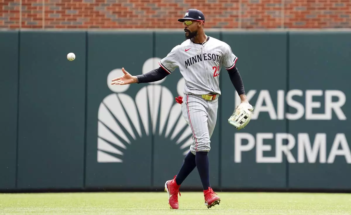 Minnesota Twins outfielder Byron Buxton (25) tosses the ball after catching it for an out off of Atlanta Braves' Ozzie Albies, not pictured, during the third inning of a baseball game Saturday, April 20, 2025, in Atlanta. (AP Photo/John David Mercer)