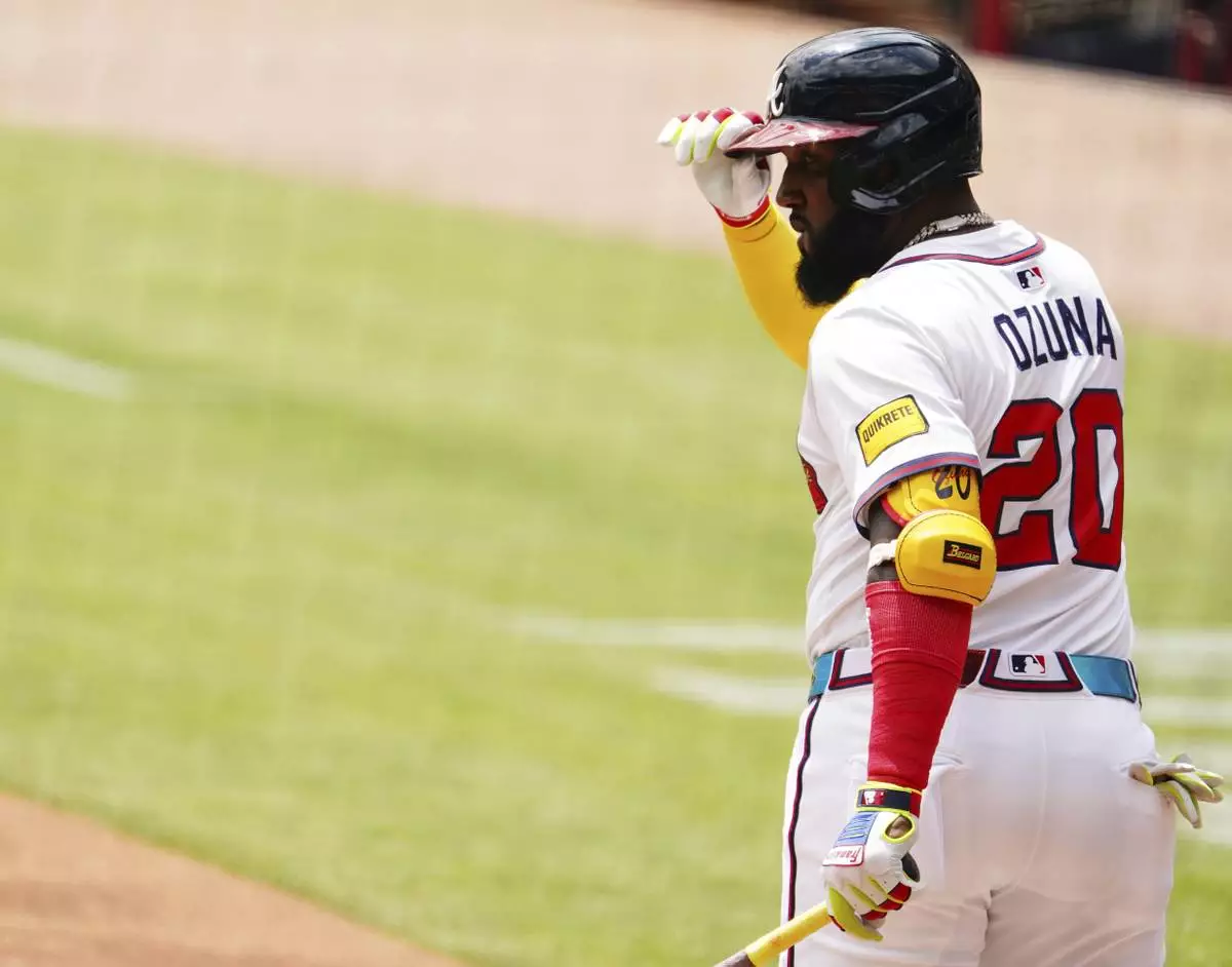 Atlanta Braves designated hitter Marcell Ozuna (20) tips his hat to the dugout while coming to the plate against the Minnesota Twins during the first inning of a baseball game Saturday, April 20, 2025, in Atlanta. (AP Photo/John David Mercer)