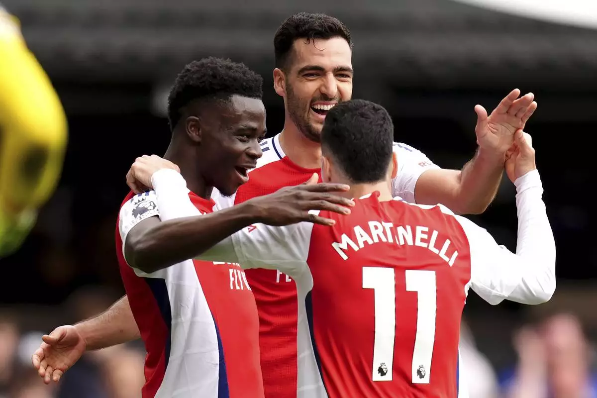 Arsenal's Gabriel Martinelli, right, celebrates scoring their side's second goal of the game during the English Premier League soccer match between Ipswich Town and Arsenal at Portman Road, Ipswich, England, Sunday, April 20, 2025. (John Walton/PA via AP)