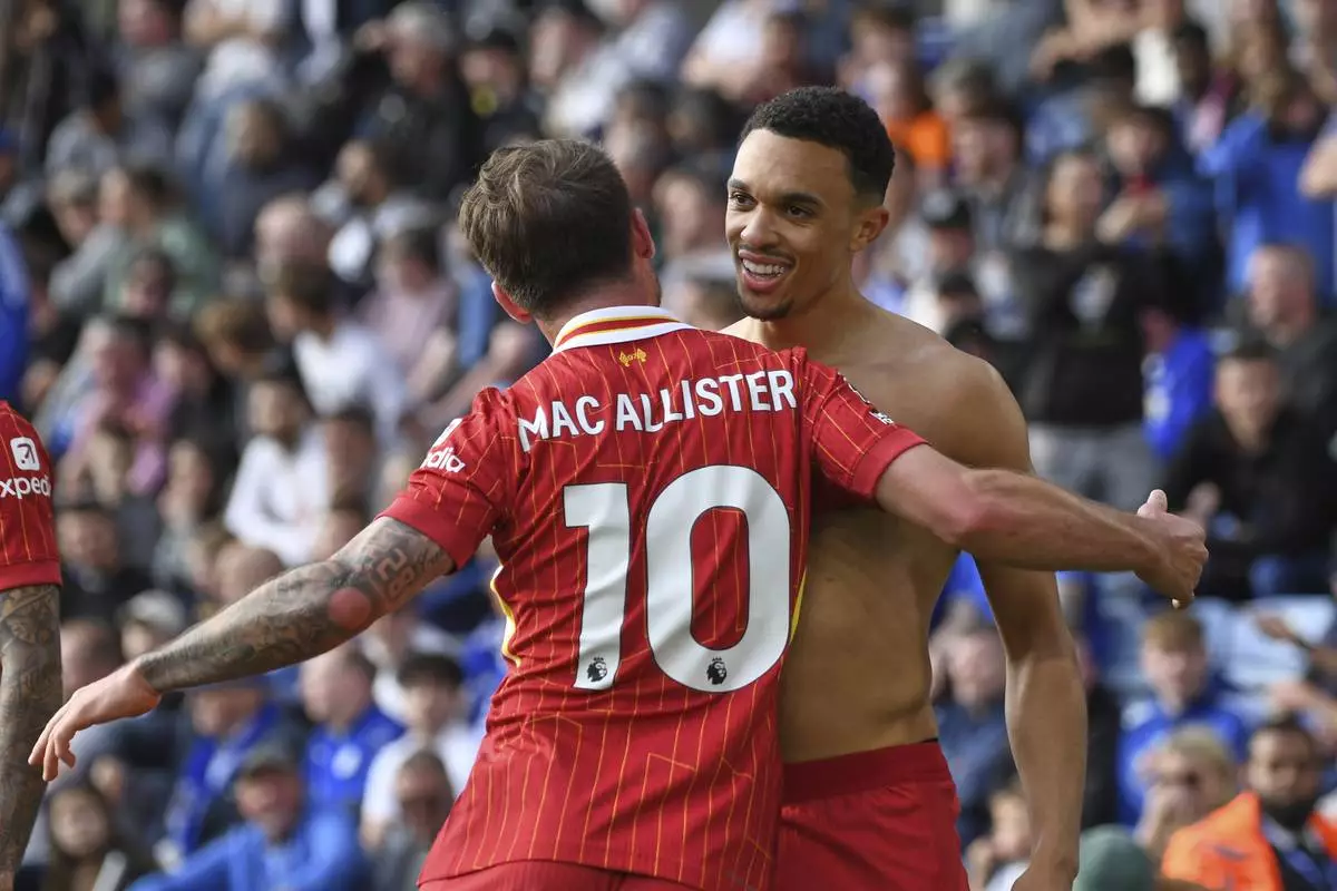 Liverpool's Trent Alexander-Arnold, right, celebrates with Liverpool's Alexis Mac Allister after scoring his side's opening goal during the English Premier League soccer match between Leicester City and Liverpool at King Power stadium in Leicester, England, Sunday, April 20, 2025. (AP Photo/Rui Vieira)