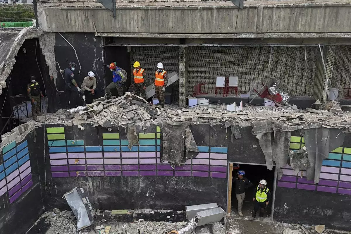 Rescue workers stand at site of the Jet Set nightclub days after its roof collapsed during a concert, killing more than 200 people in Santo Domingo, Dominican Republic, Thursday, April 10, 2025. (AP Photo/Matias Delacroix)