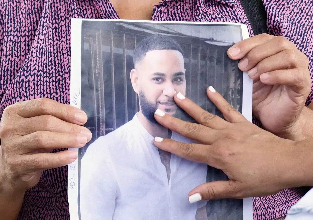 A woman touches a photo of one of the missing during the search for survivors at the Jet Set nightclub after its roof collapsed two nights prior during a merengue concert in Santo Domingo, Dominican Republic, Wednesday, April 9, 2025. (AP Photo/Ricardo Hernandez)
