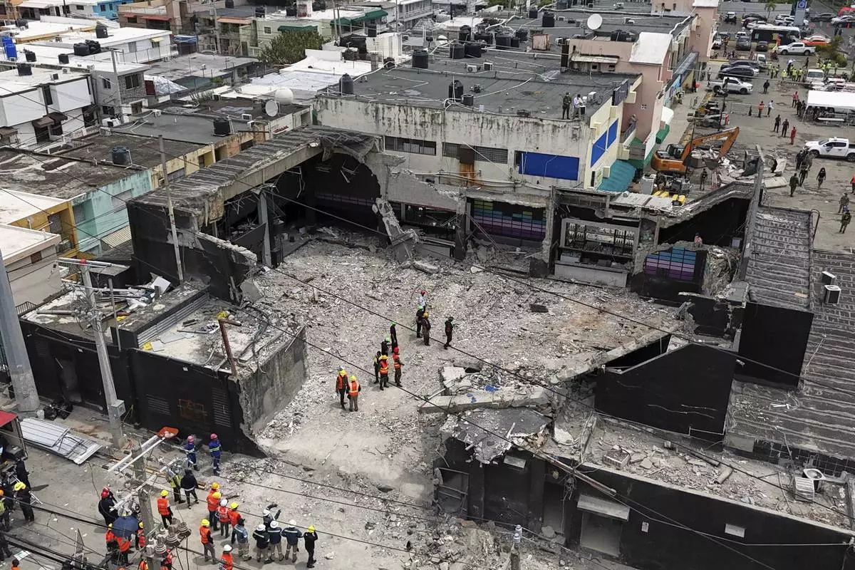 Rescue workers stand at the Jet Set nightclub after its roof collapsed, killing more than 200 people in Santo Domingo, Dominican Republic, Thursday, April 10, 2025. (AP Photo/Matias Delacroix)