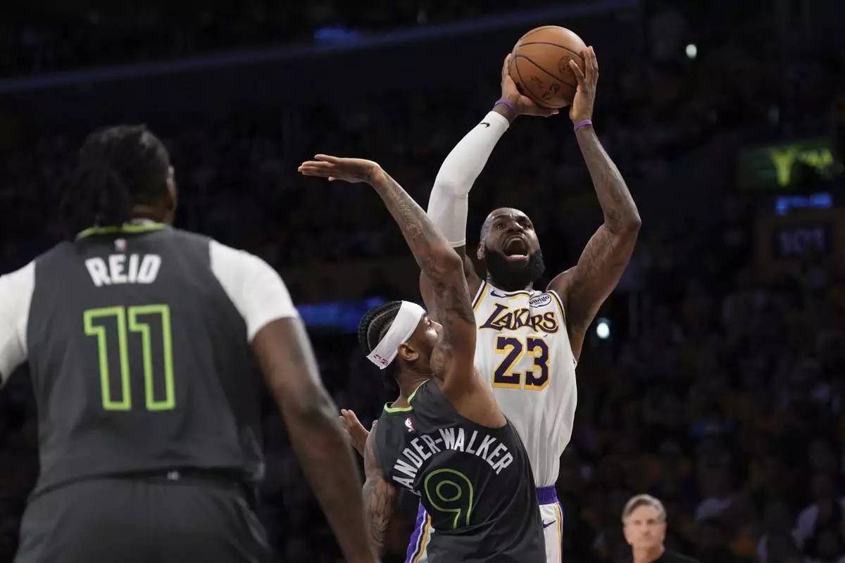 Los Angeles Lakers forward LeBron James, right, shoots as Minnesota Timberwolves guard Nickeil Alexander-Walker, center, and center Naz Reid defend during the first half in Game 1 of an NBA first-round playoff series Saturday, April 19, 2025, in Los Angeles. (AP Photo/Mark J. Terrill)