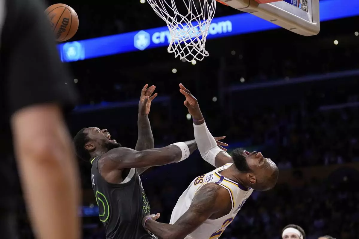Los Angeles Lakers forward LeBron James, right, reacts after being hit in the face by Minnesota Timberwolves forward Julius Randle as Randle was shooting during the second half in Game 1 of an NBA first-round playoff series Saturday, April 19, 2025, in Los Angeles. (AP Photo/Mark J. Terrill)