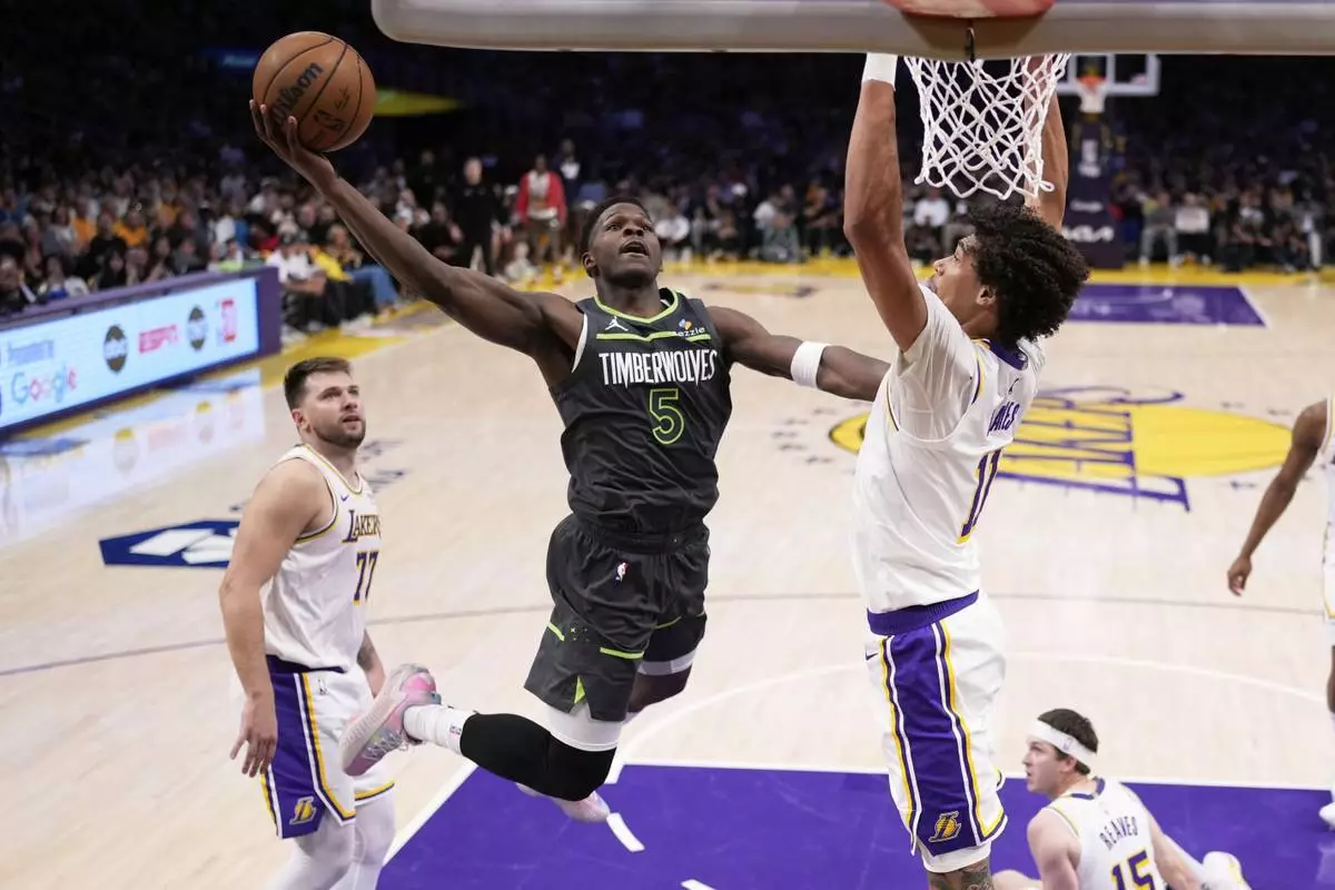 Minnesota Timberwolves guard Anthony Edwards, center, shoots as Los Angeles Lakers center Jaxson Hayes, right, and guard Luka Doncic defend during the first half in Game 1 of an NBA first-round playoff series Saturday, April 19, 2025, in Los Angeles. (AP Photo/Mark J. Terrill)