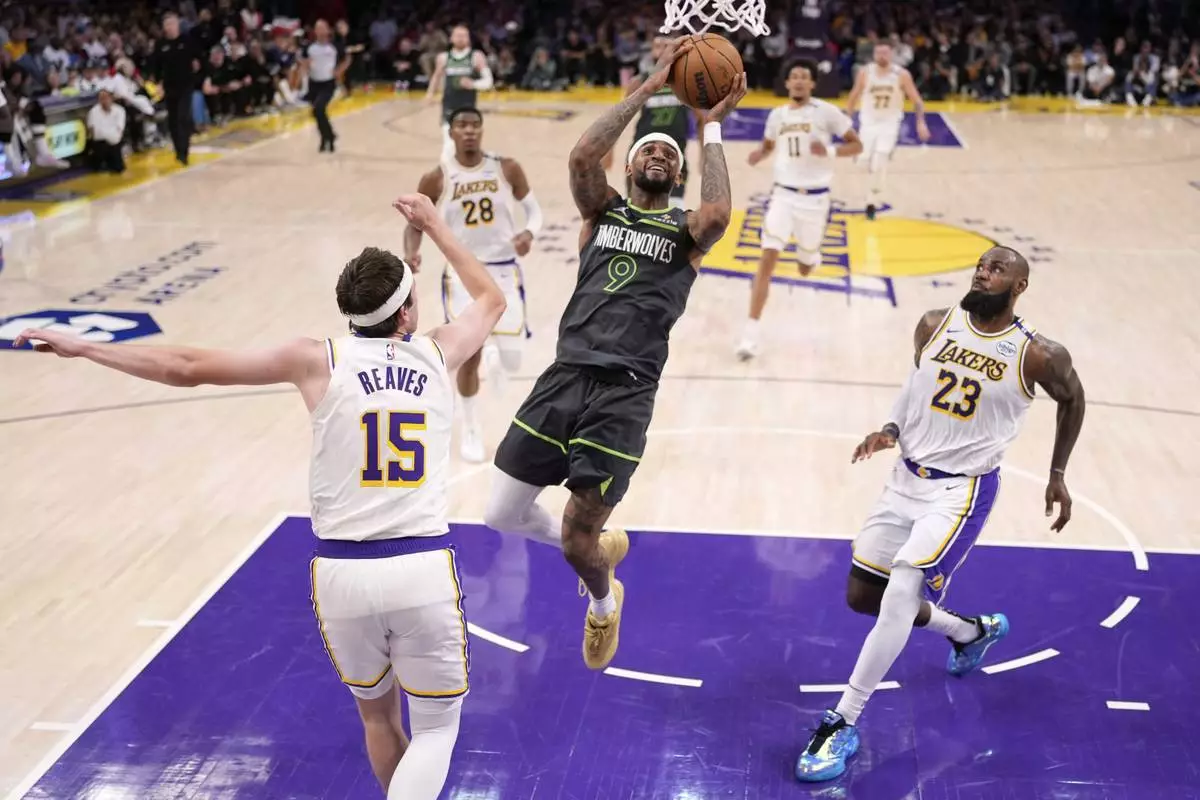 Minnesota Timberwolves guard Nickeil Alexander-Walker (9) shoots as Los Angeles Lakers guard Austin Reaves (15) and forward LeBron James (23) defend during the first half in Game 1 of an NBA first-round playoff series Saturday, April 19, 2025, in Los Angeles. (AP Photo/Mark J. Terrill)