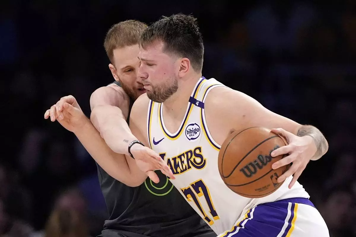 Los Angeles Lakers guard Luka Doncic, right, dries toward the basket as Minnesota Timberwolves guard Donte DiVincenzo defends during the second half in Game 1 of an NBA first-round playoff series Saturday, April 19, 2025, in Los Angeles. (AP Photo/Mark J. Terrill)