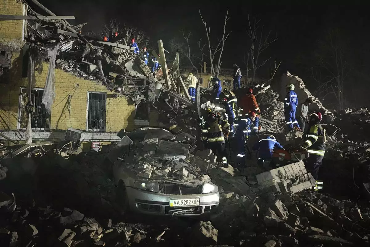 Ukrainian search personnel clear the rubble after a Russian ballistic missile attack in Kyiv, Ukraine, early Thursday, April 24, 2025. (AP Photo/Efrem Lukatsky)