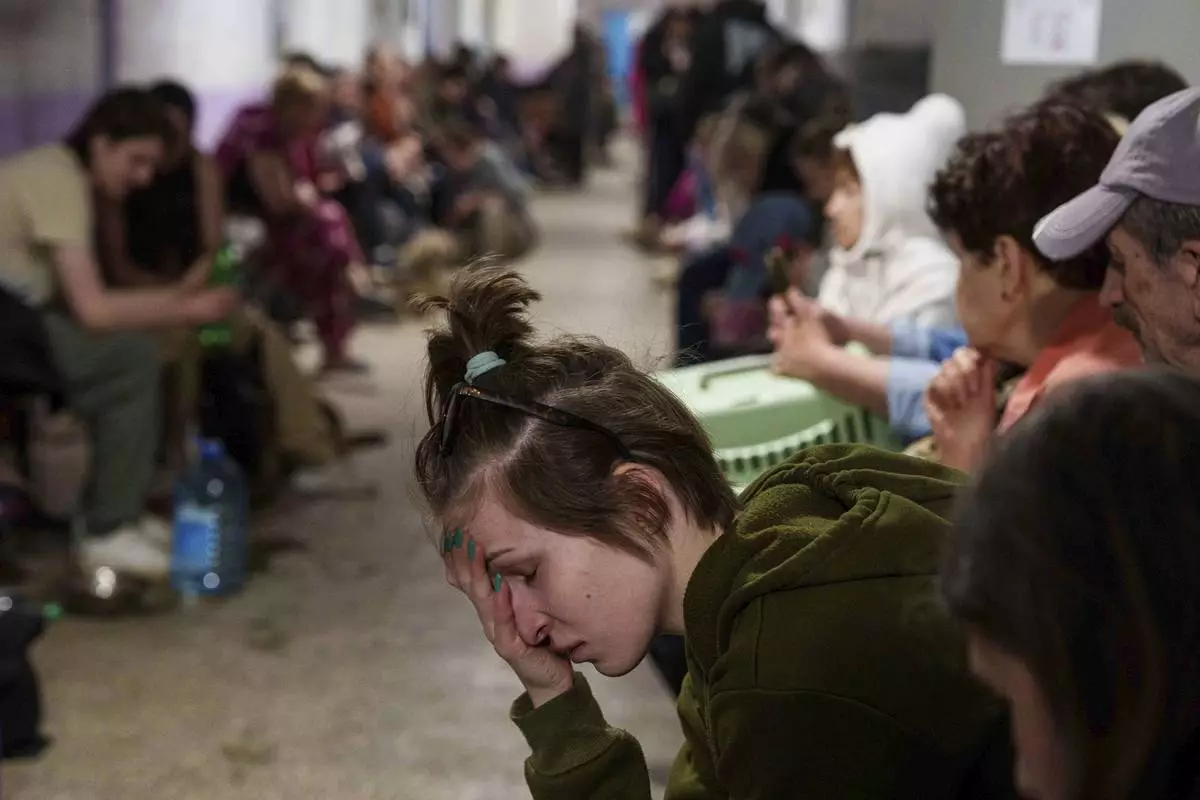 A woman sits in a school basement being used as a shelter after a Russian airstrike on a residential neighborhood in Kyiv, Ukraine, on Thursday, April 24, 2025. (AP Photo/Evgeniy Maloletka)