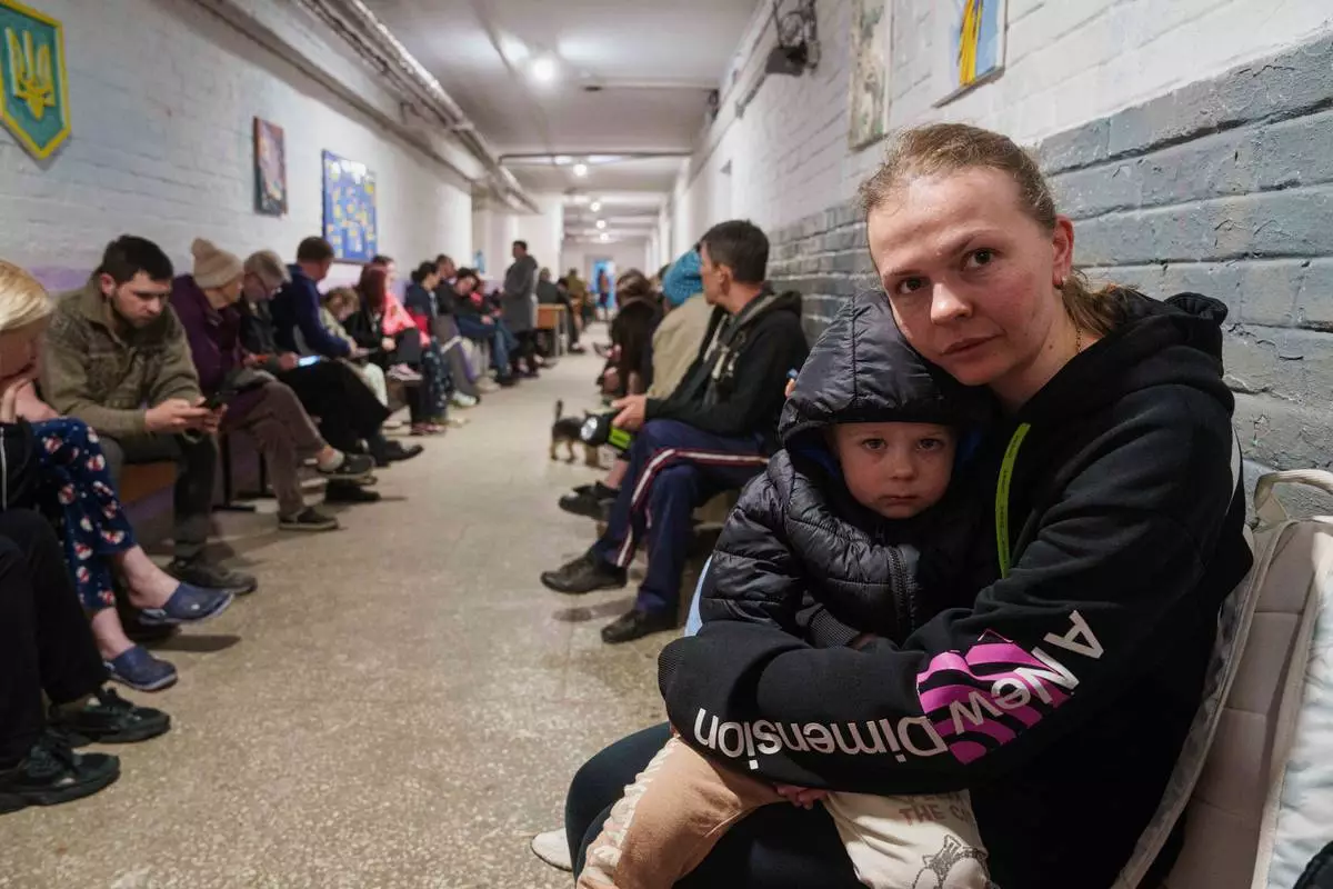 A mother comforts her son in a school basement being used as a shelter after a Russian airstrike on a residential neighborhood in Kyiv, Ukraine, on Thursday, April 24, 2025. (AP Photo/Evgeniy Maloletka)