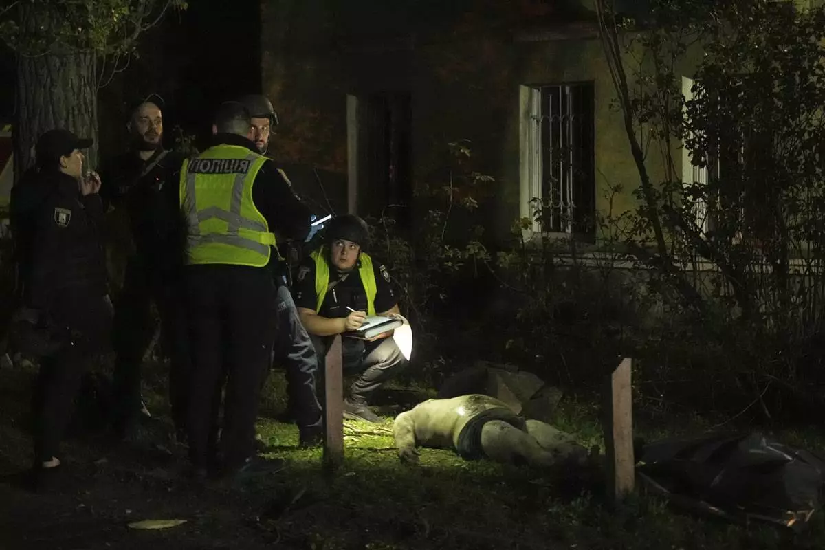 EDS NOTE: GRAPHIC CONTENT - Police officers inspect a dead body after a Russian ballistic missile attack in Kyiv, Ukraine, early Thursday, April 24, 2025. (AP Photo/Efrem Lukatsky)