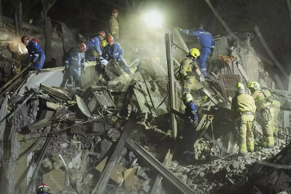 Ukrainian searchers clear the rubble after a Russian ballistic missile attack in Kyiv, Ukraine, early Thursday, April 24, 2025. (AP Photo/Efrem Lukatsky)